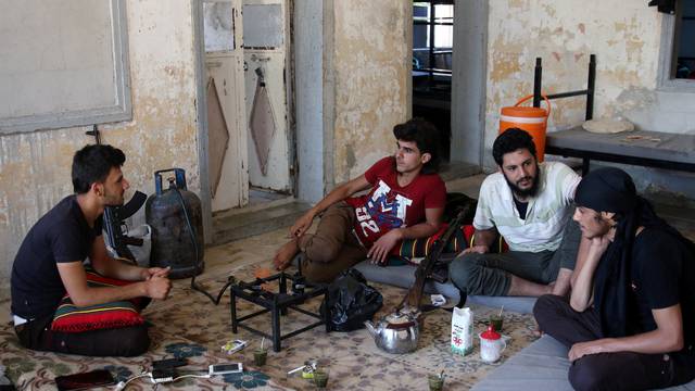 Free Syrian Army fighters rest inside a room in Quneitra
