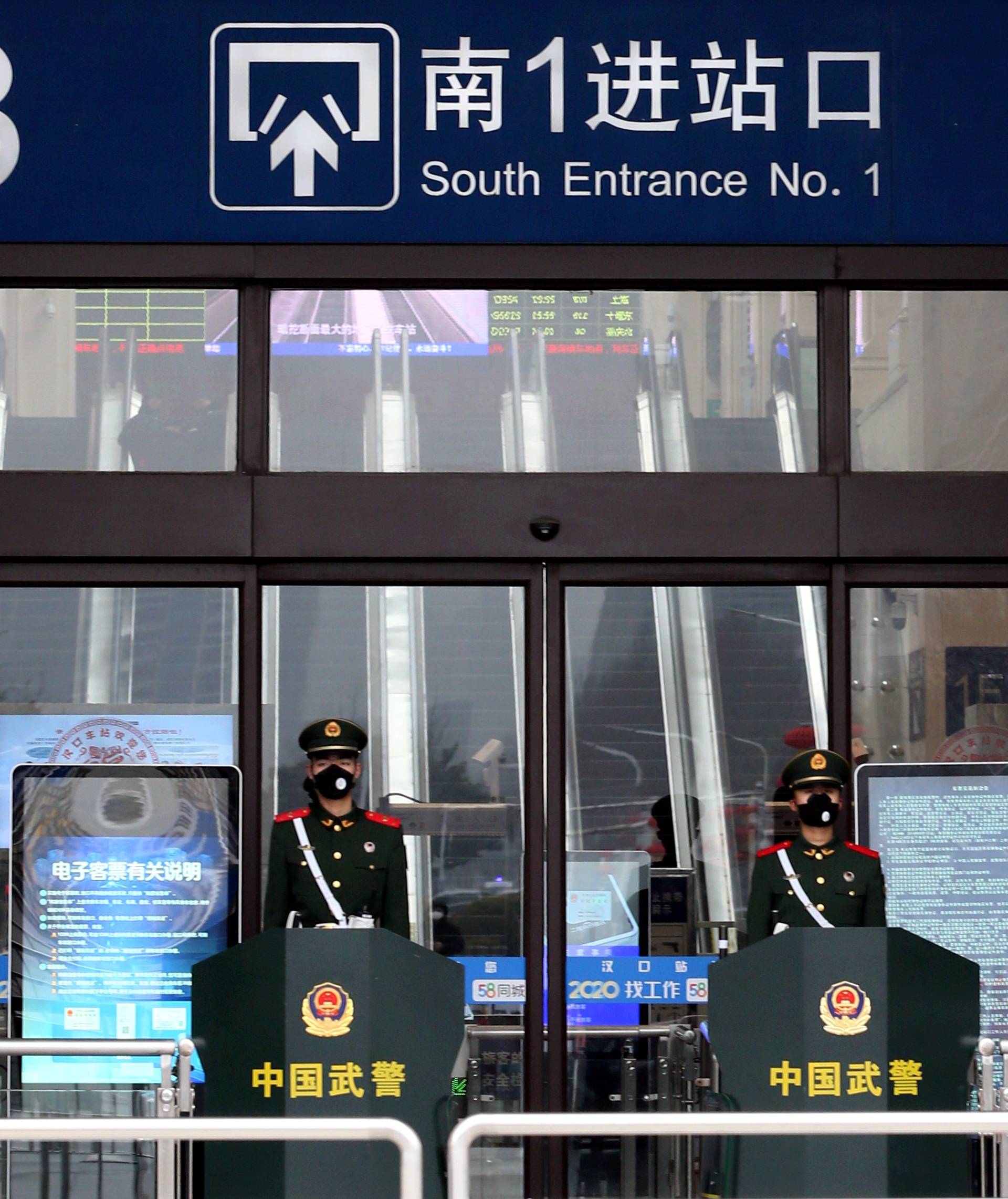 Chinese paramilitary officers wearing masks stand guard at an entrance of the closed Hankou Railway Station after the city was locked down following the outbreak of a new coronavirus in Wuhan