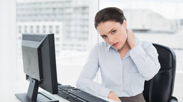 Businesswoman with neck pain sitting at office