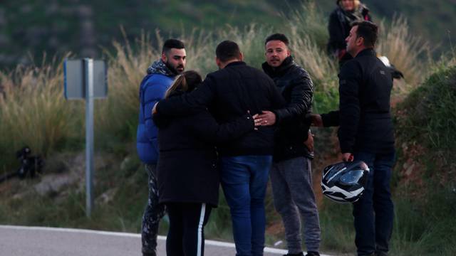 People comfort each other on a road after leaving the area where Julen, a Spanish two-year-old boy who fell into a deep well four days ago in Totalan