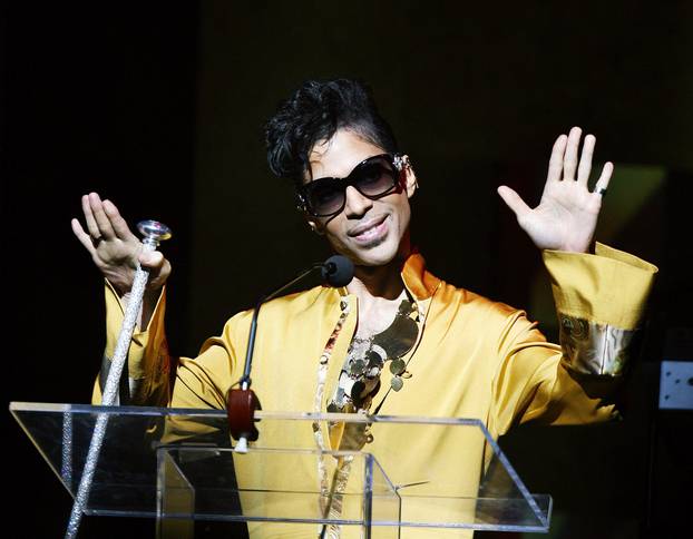 Musician Prince gestures on stage during Apollo Theatre