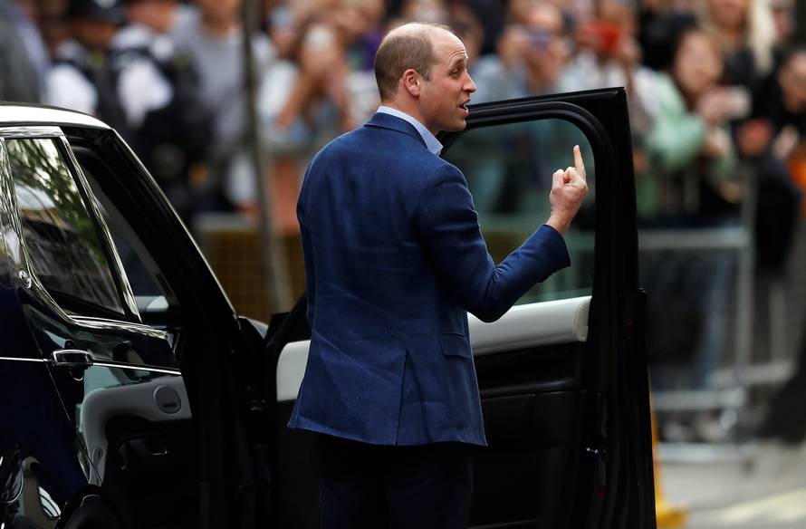 Britain's Prince William gestures as he prepares to leave Lindo Wing of St Mary's Hospital with Catherine, the Duchess of Cambridge and their new baby boy in London
