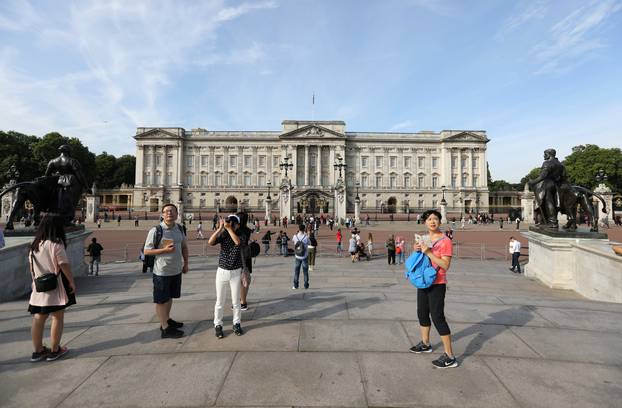 Tourists are seen outside Buckingham Palace in London