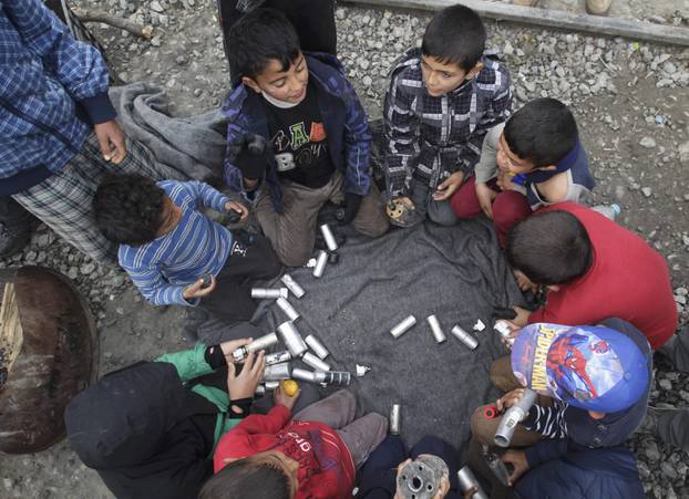 Migrant children play with rubber bullets and empty cases at a makeshift camp for refugees and migrants at the Greek-Macedonian border near the village of Idomeni