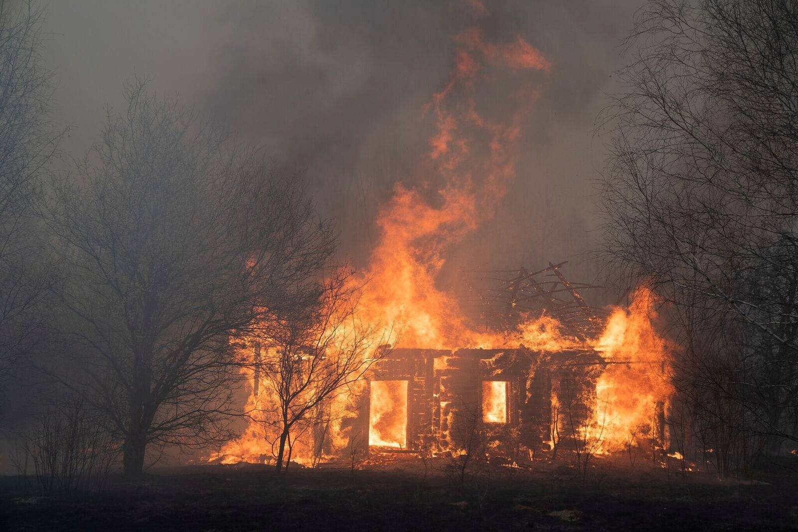 FILE PHOTO: A view shows a wooden house on fire in Lyudvynivka in Kiev Region