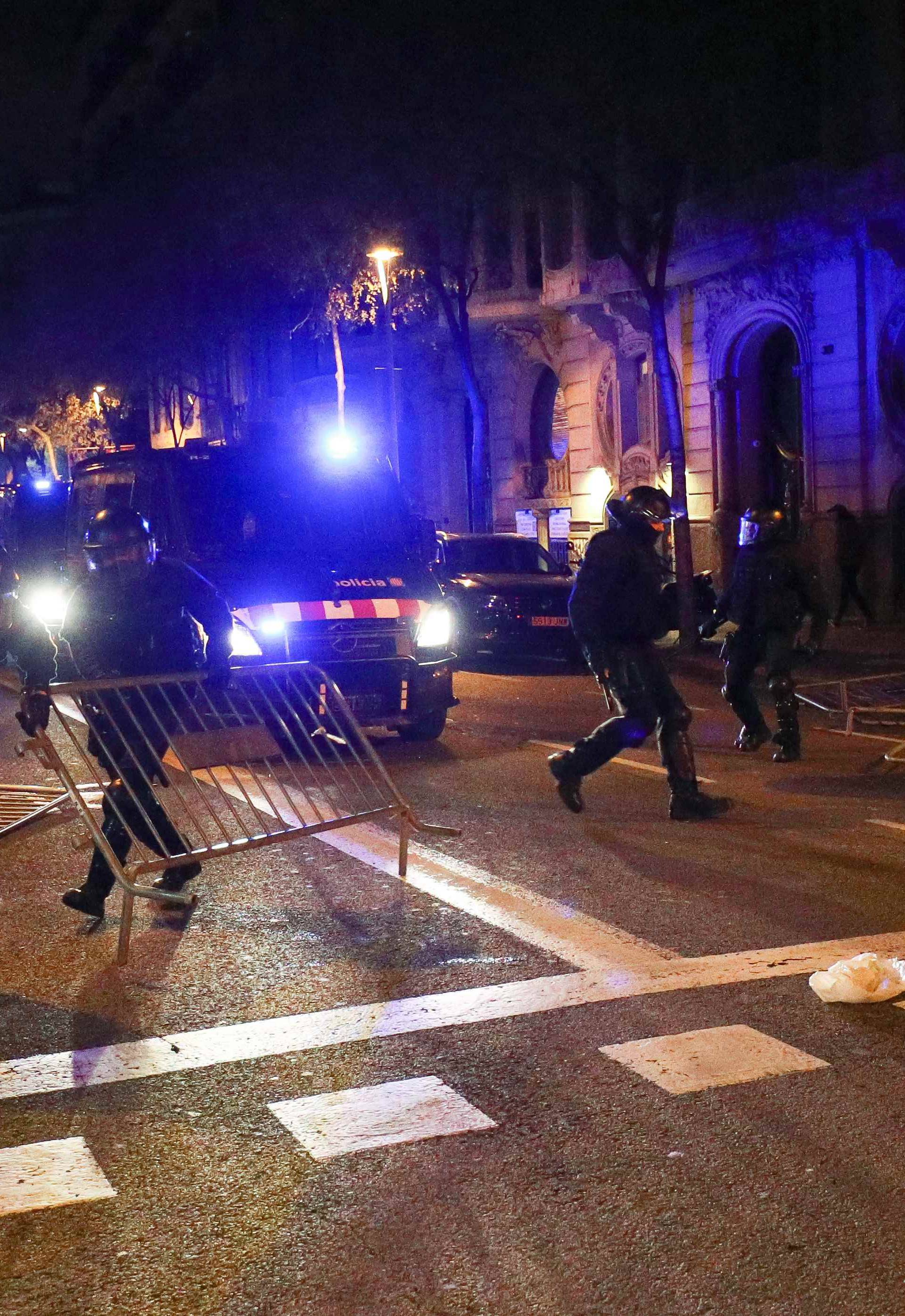 Catalan police remove barricades placed by protestors during skirmishes after former regional president Carles Puigdemont was detained in Germany,  in Barcelona