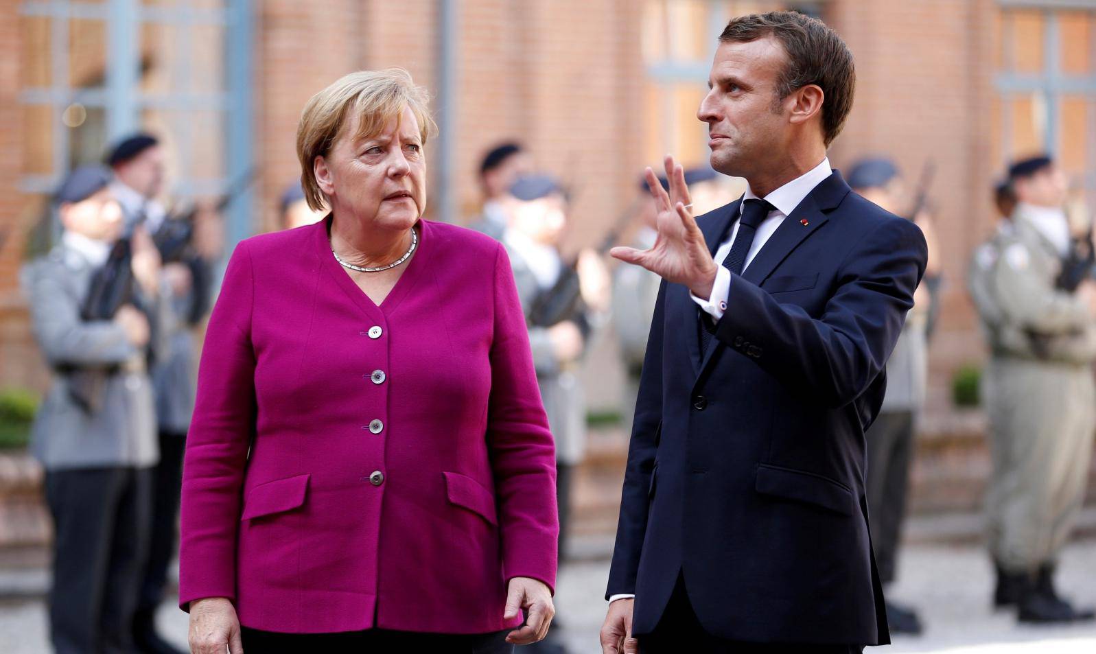 FILE PHOTO: French President Emmanuel Macron welcomes German Chancellor Angela Merkel before a joint Franco-German cabinet meeting in Toulouse