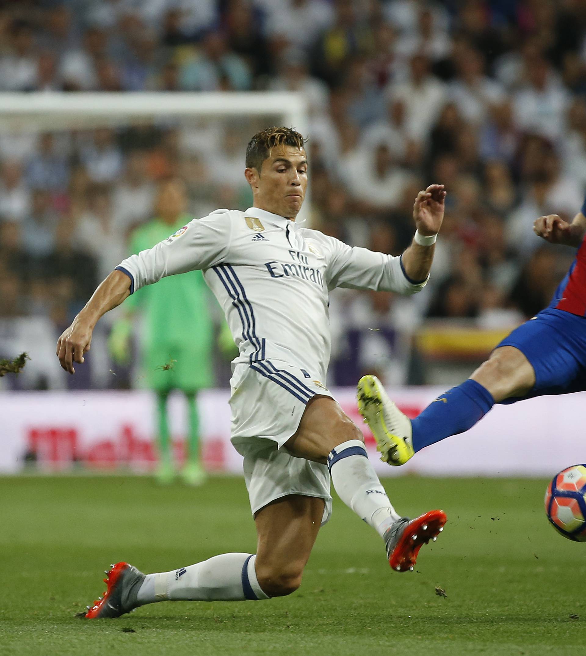 Barcelona's Andres Iniesta in action with Real Madrid's Cristiano Ronaldo