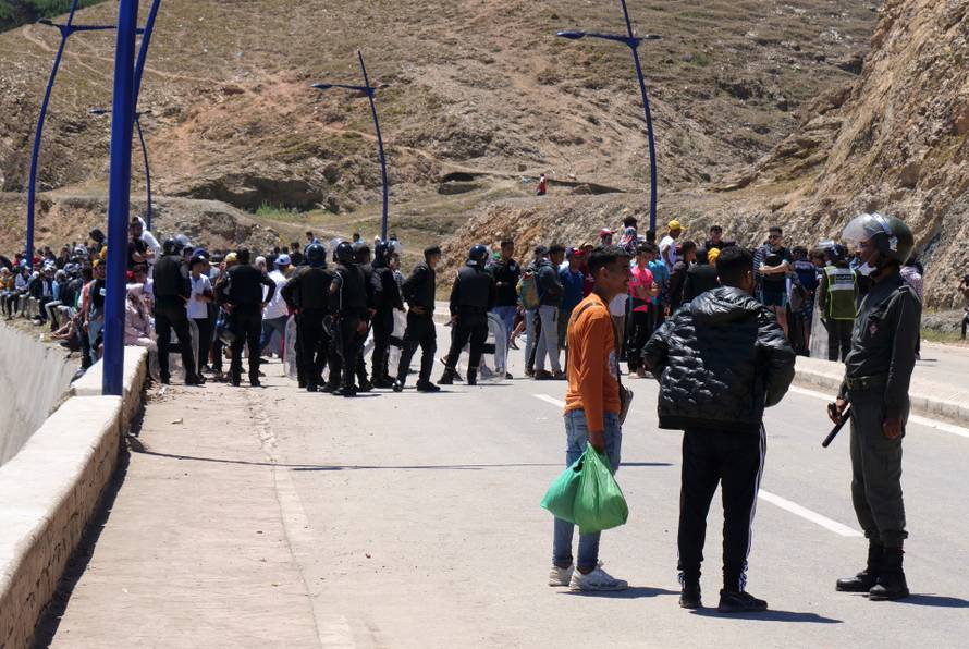 A police officer talks to migrant in Fnideq, close to the Spanish enclave Ceuta