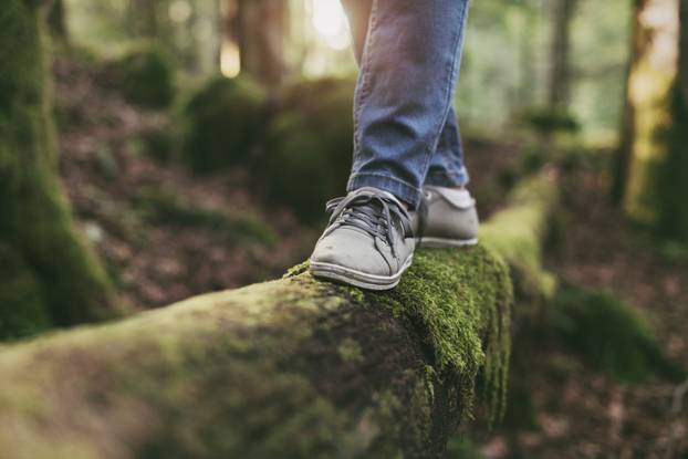 Woman walking on a log in the forest