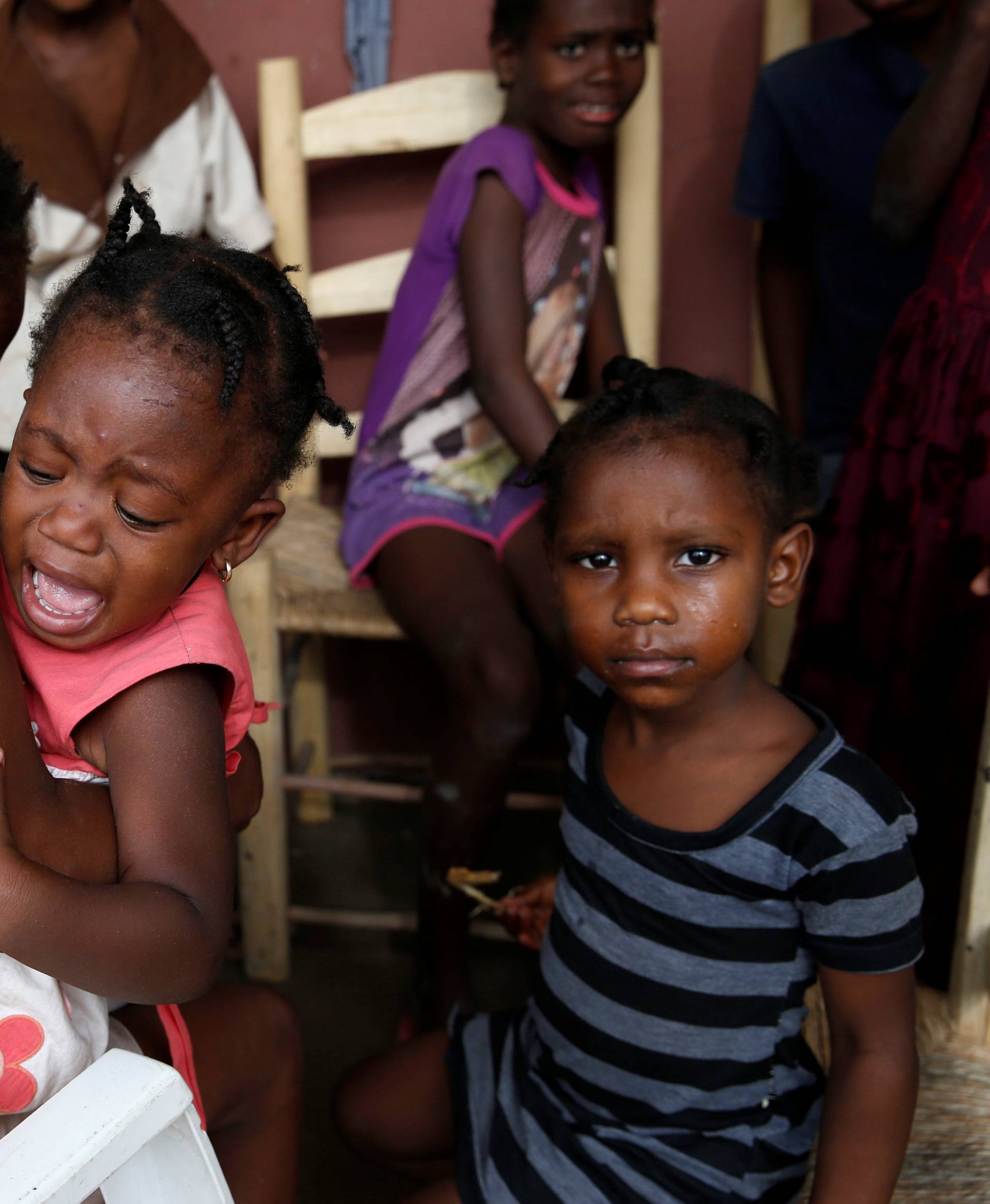 A girl cries as she stays with her relatives at a partially destroyed school after Hurricane Matthew passes Jeremie, Haiti