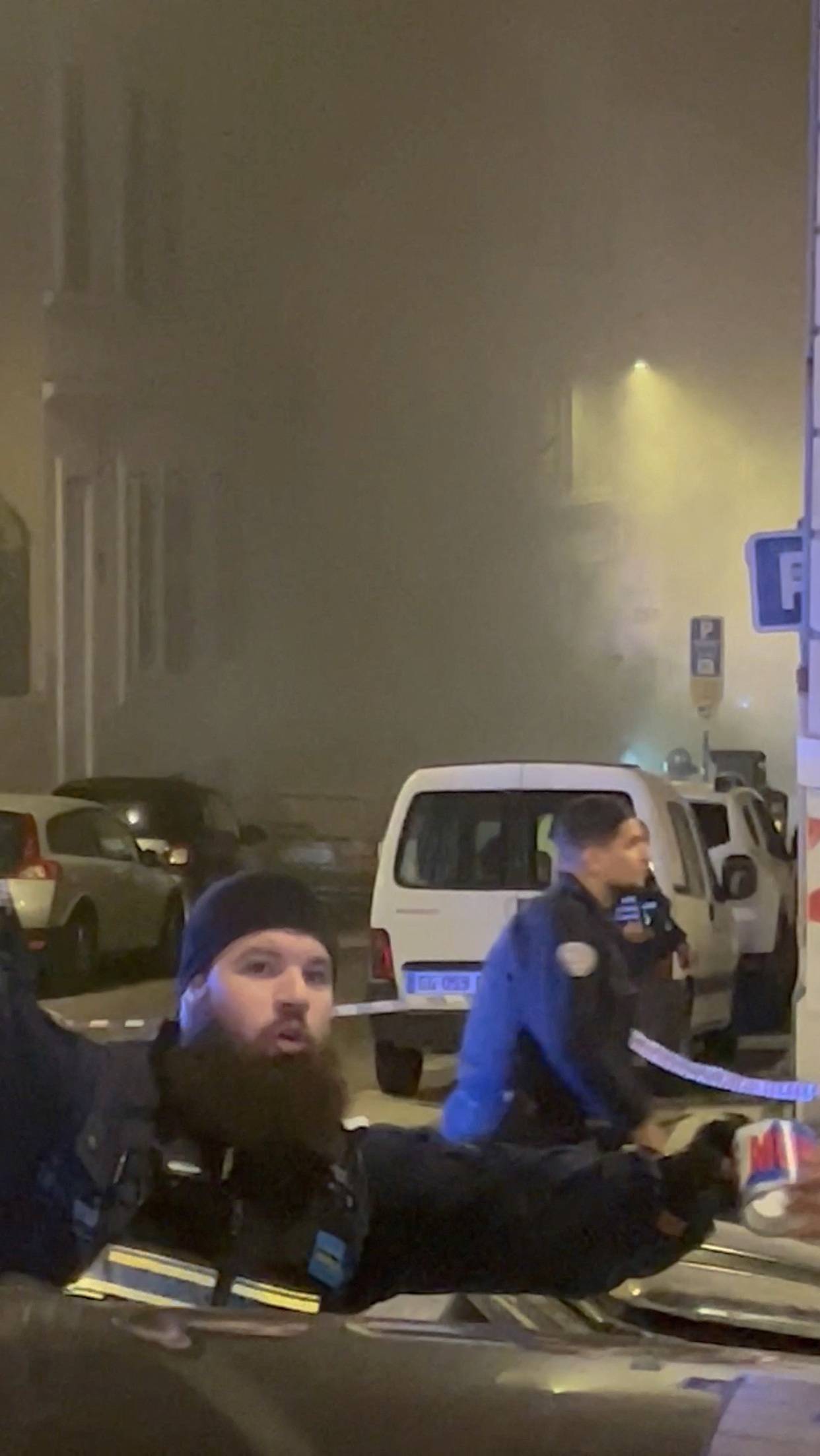 Smoke envelopes the area as police officers work at the scene of a fire following a gas explosion in Marseille