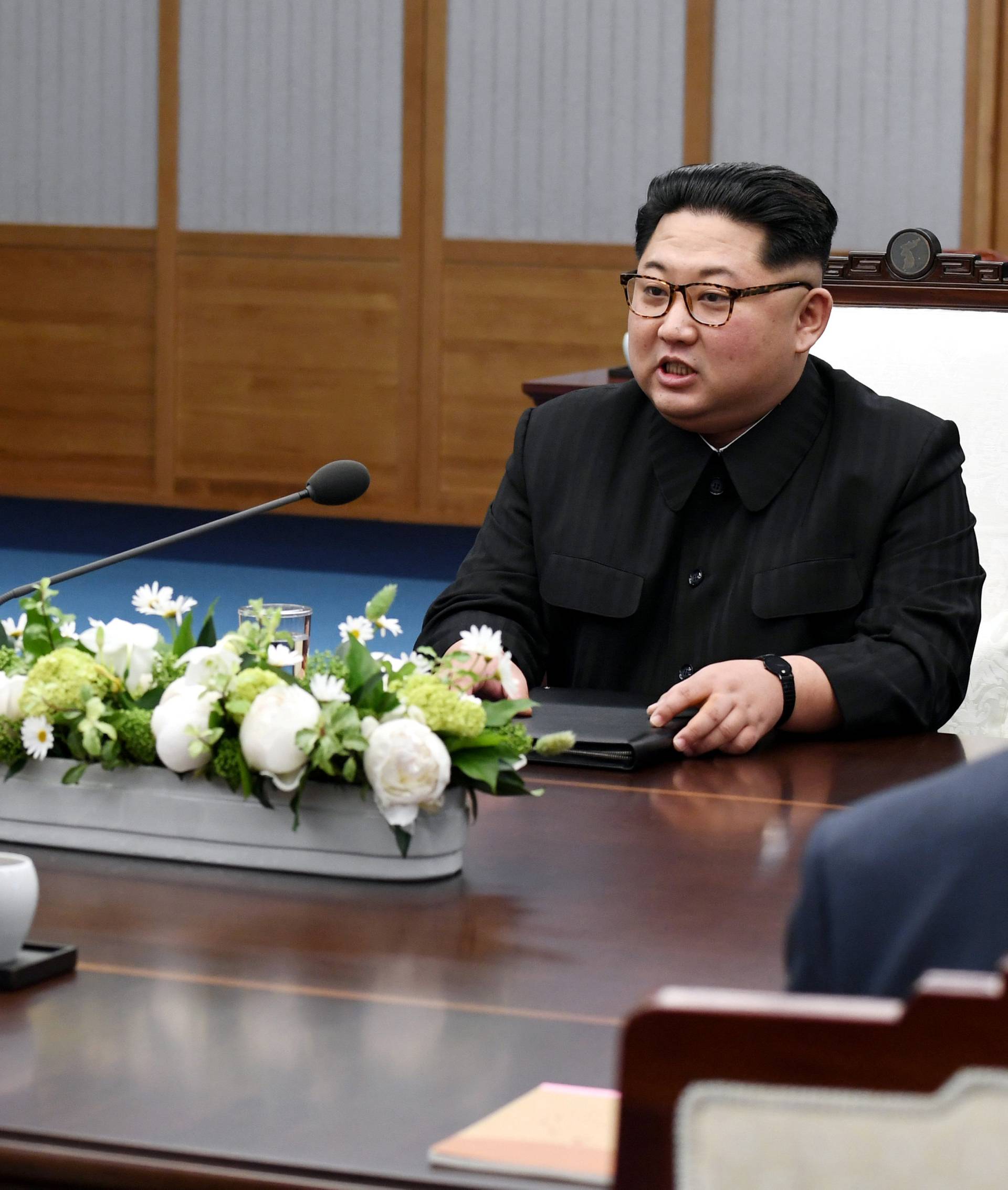 North Korean leader Kim Jong Un talks to South Korean President Moon Jae-in during their meeting at the Peace House