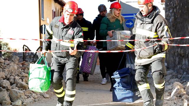 Firefighters help residents to carry their belongings in the ancient city of Norcia