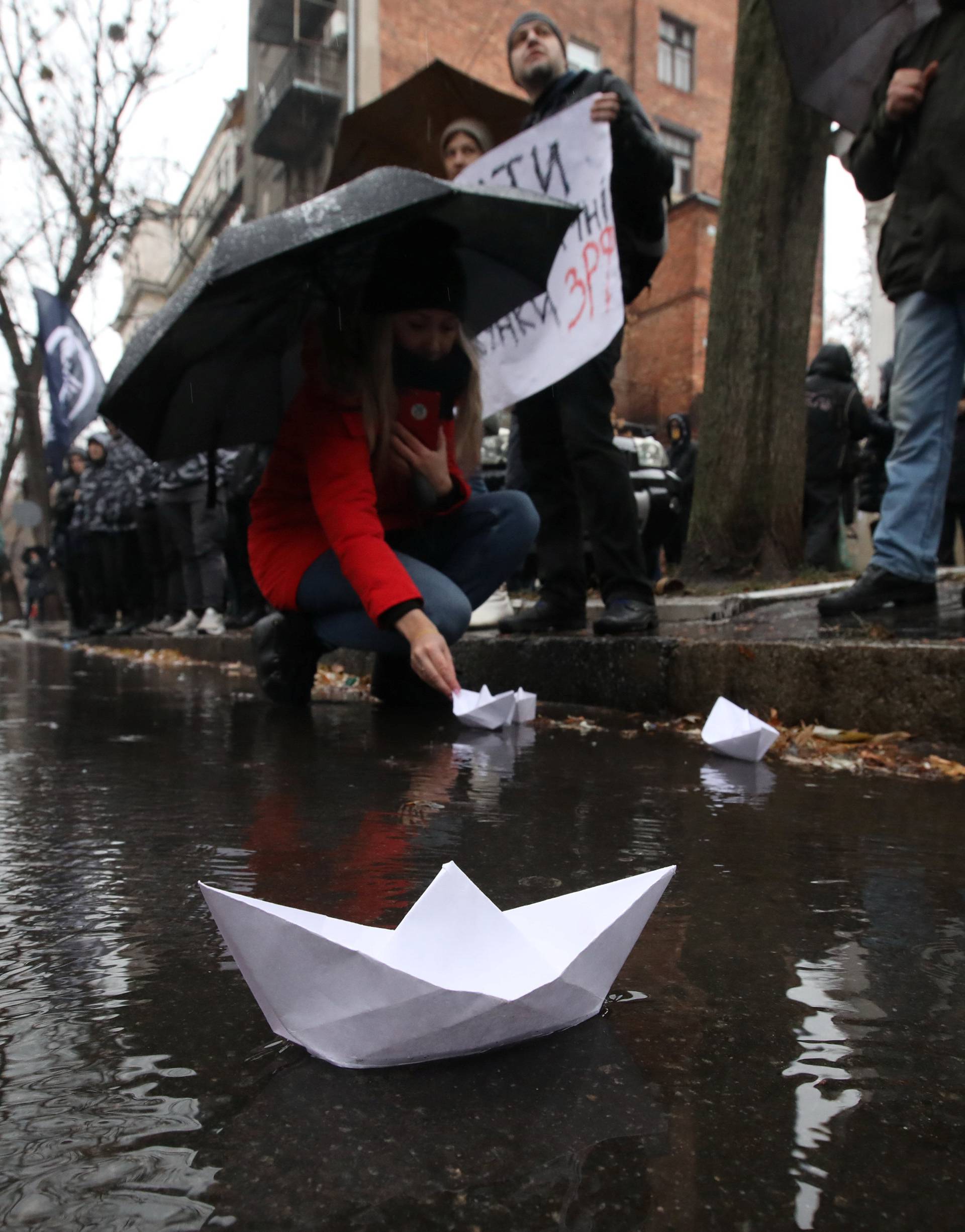 A demonstrator launches a paper boat during a rally to support the Ukrainian navy in front of the Russia Consulate in Kharkiv