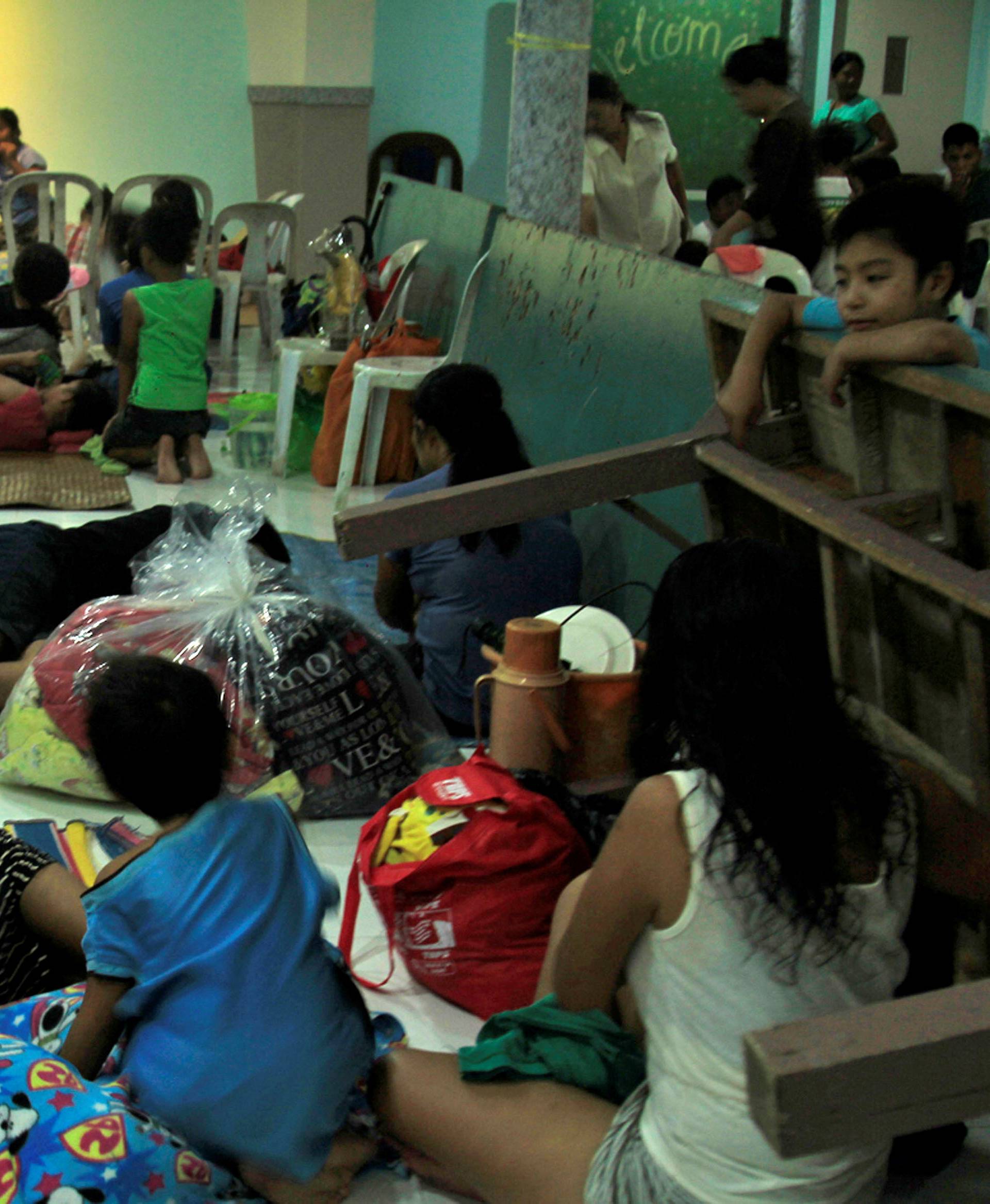 Residents celebrating Christmas Day at the evacuation center take a break before Typhoon Nock-ten is expected to strike Legazpi City