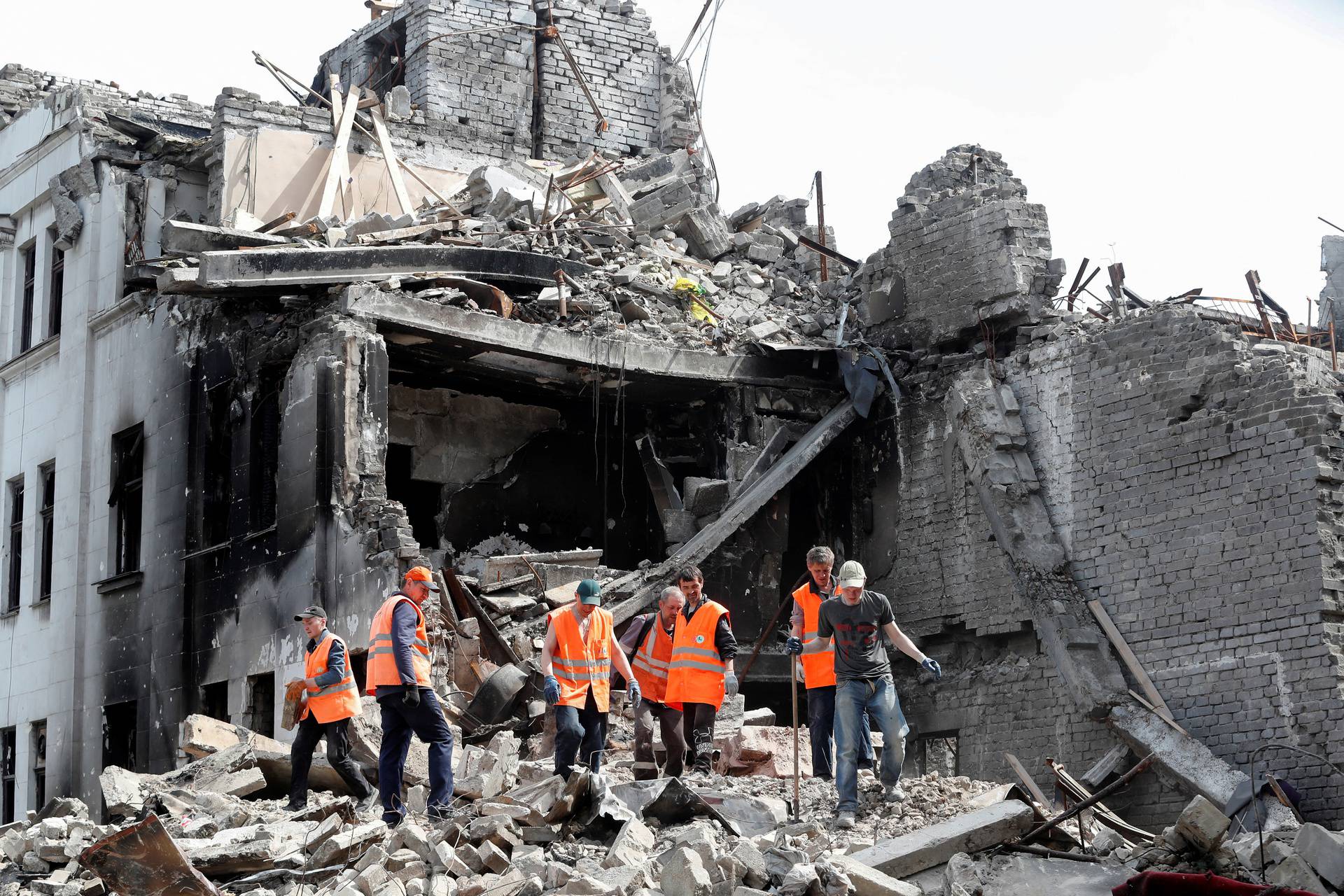 People remove the debris of a theatre building in Mariupol