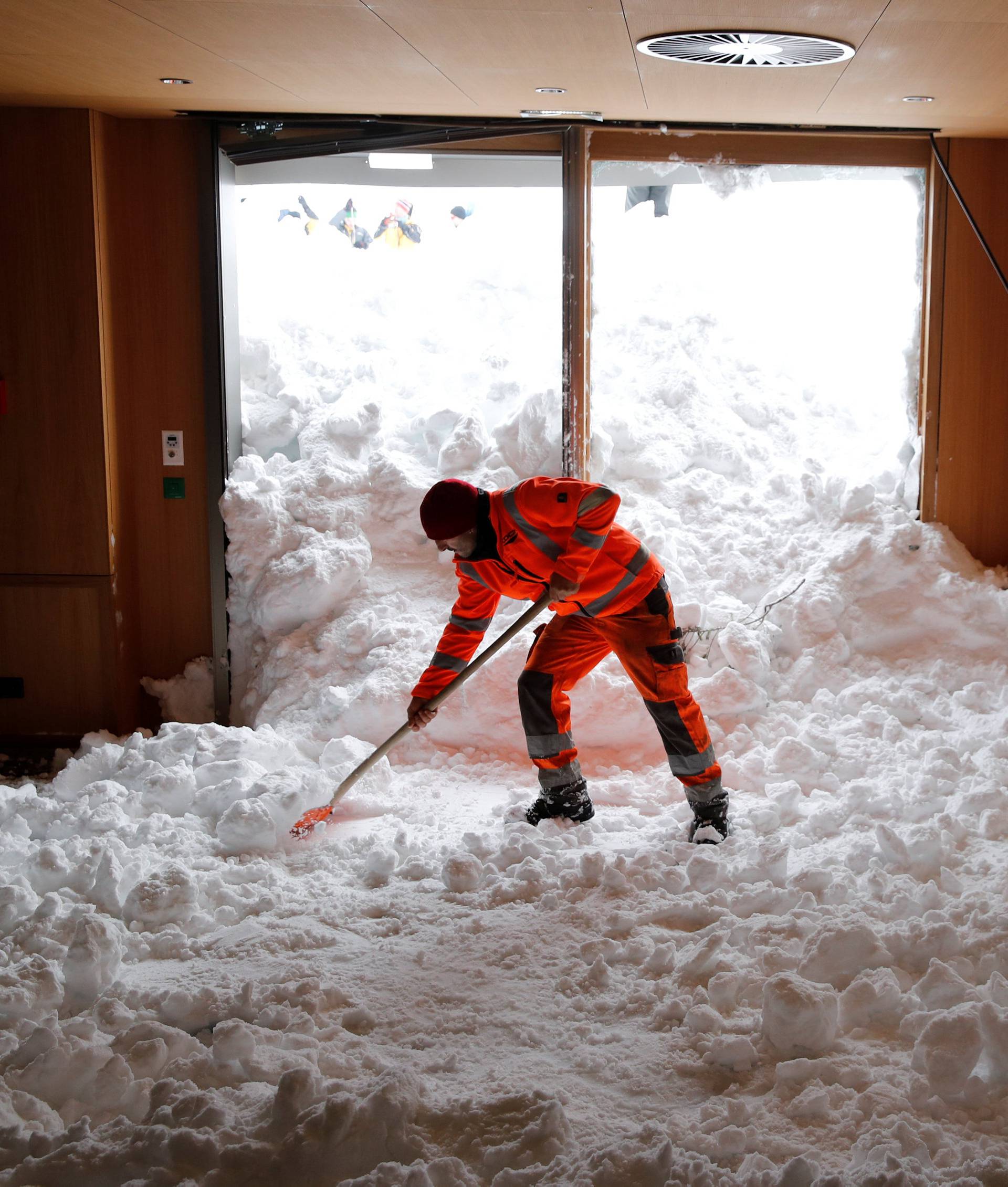 Worker shovels snow out of a restaurant after an avalanche at Santis-Schwaegalp