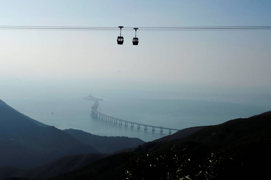 Cable cars move in front of the Hong Kong-Zhuhai-Macau bridge off Lantau island in Hong Kong