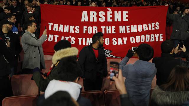 Arsenal fans hold up a banner protesting against Arsenal manager Arsene Wenger after the game