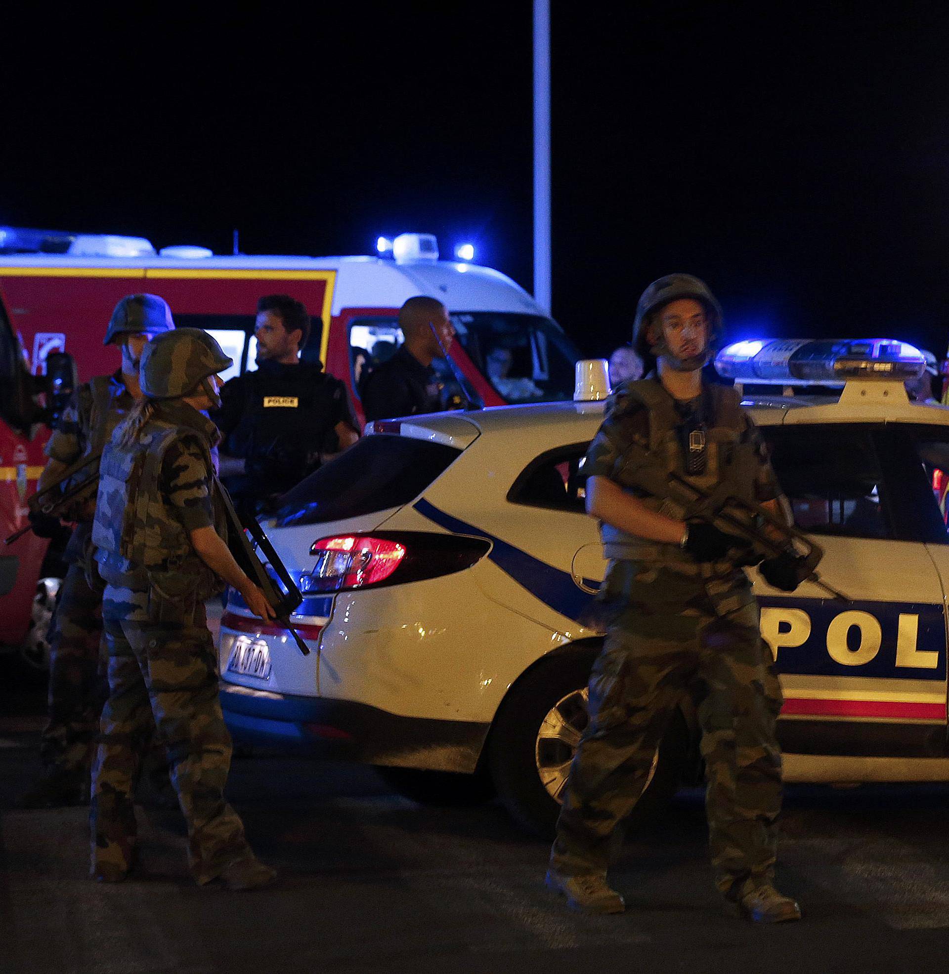 French soldiers and rescue forces are seen at the scene whare at least 30 people were killed in Nice when a truck ran into a crowd celebrating the Bastille Day national holiday