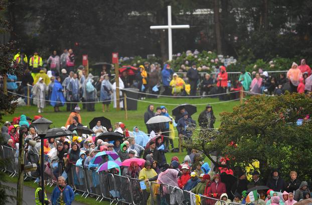 The faithful wait in the rain ahead of a visit of Pope Francis to Knock Shrine in Knock