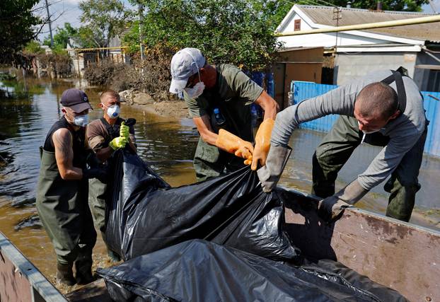 Volunteers and municipal workers retrieve bodies from flooded houses in Hola Prystan