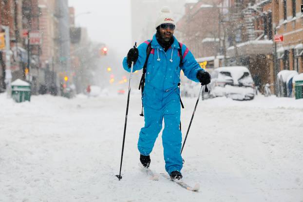 A man skis through the East Village during a snow storm in New York