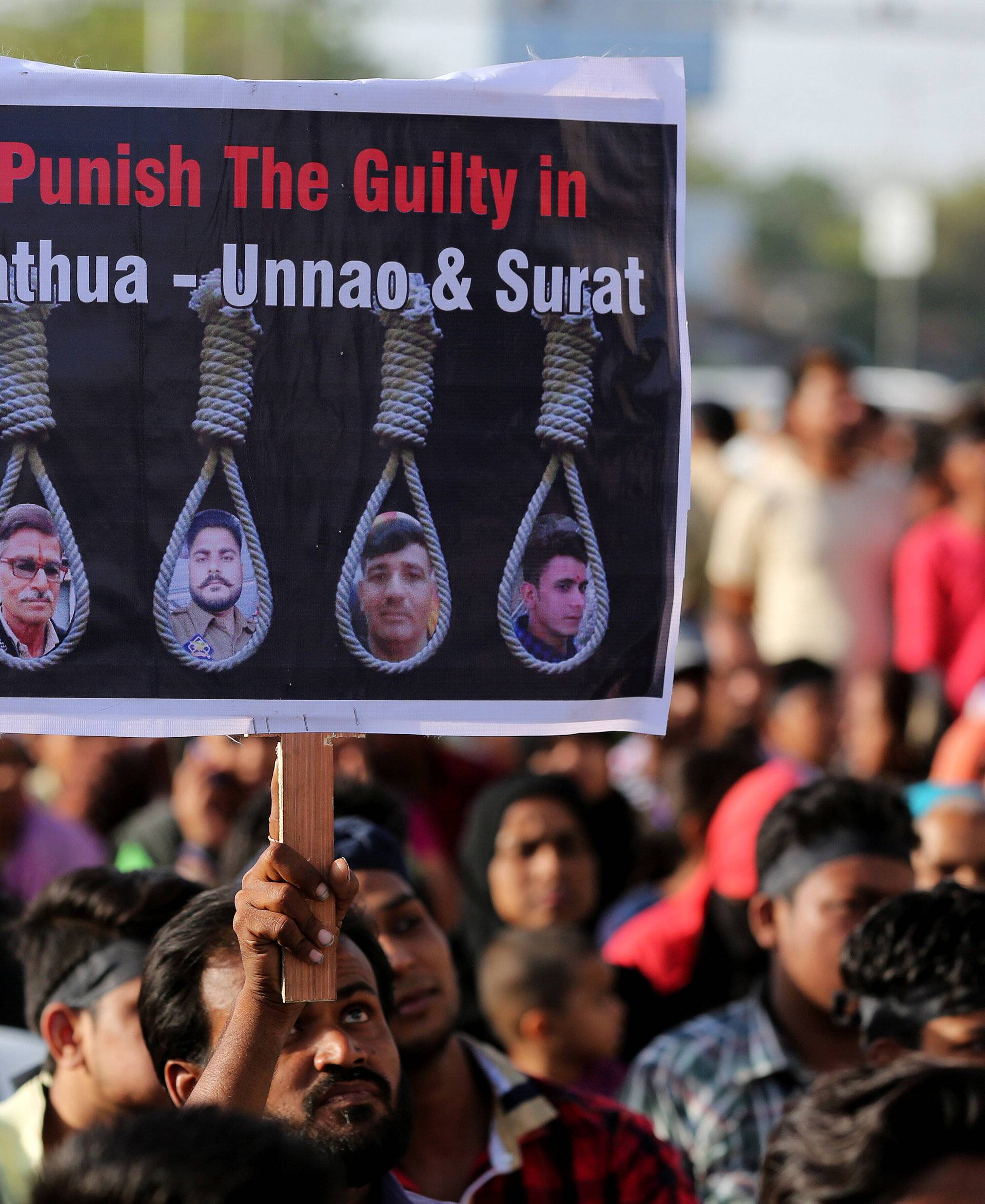 People hold placards at a protest against the rape of an eight-year-old girl, in Kathua, near Jammu, a teenager in Unnao, Uttar Pradesh state, and an eleven-year-old girl in Surat, in Ahmedabad