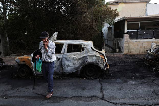 Uri, 83, talks on the phone after a rocket launched from the Gaza Strip damaged his home when it landed in Ashkelon, southern Israel