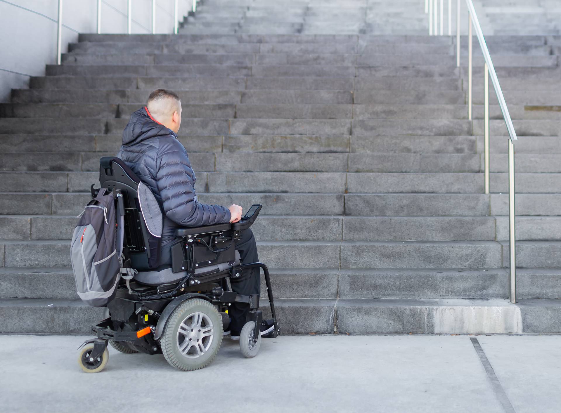 Man on a wheelchair looking at stairs