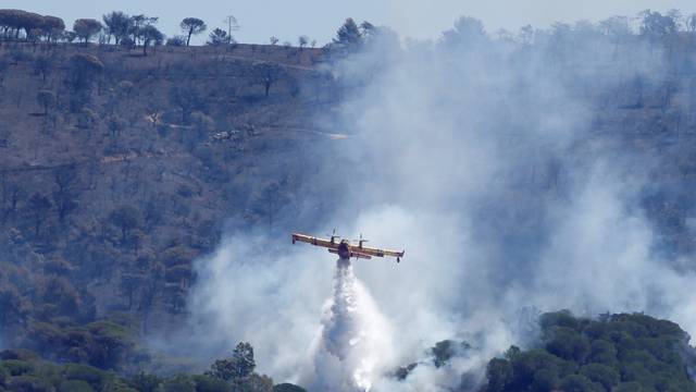 A Canadair firefighting plane drops water to extinguish a forest fire on La Croix-Valmer from Cavalaire-sur-Mer