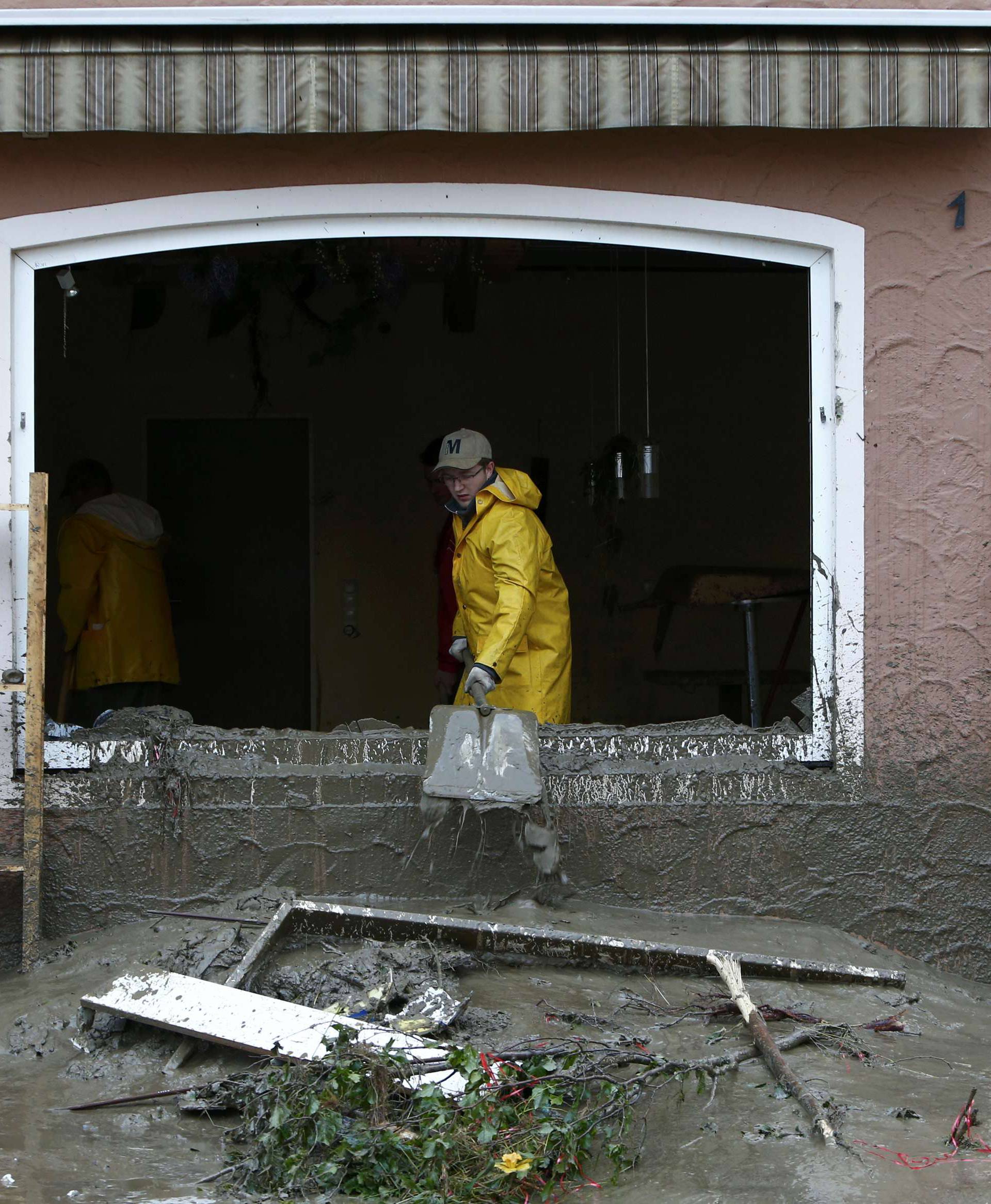 A man removes mud from a house damaged by floods in the Bavarian village of Simbach am Inn