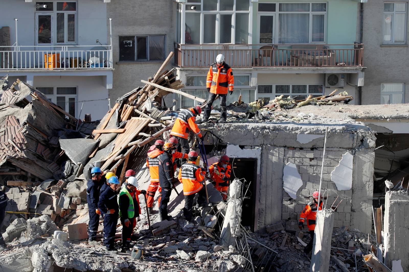 Rescue workers search the site of a collapsed building, after an earthquake in Elazig