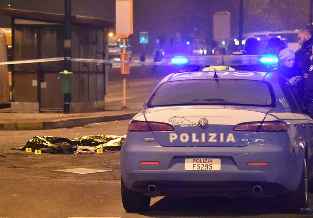 The body of Anis Amri, the suspect in the Berlin Christmas market truck attack, is seen covered with a thermal blanket next to Italian Police officers in a suburb of the northern Italian city of Milan