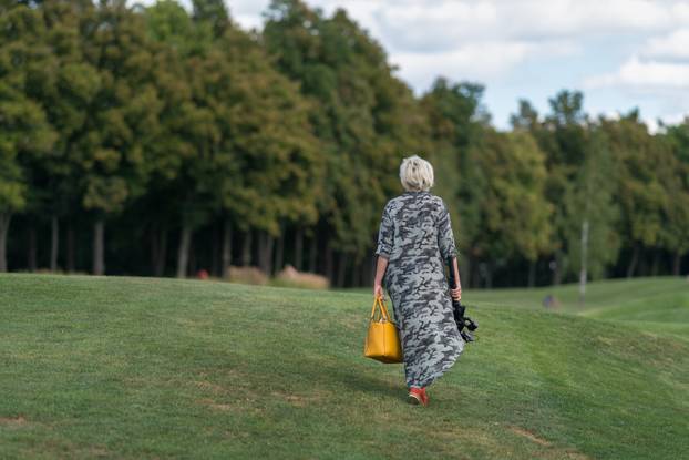 Woman in a long dress walking over grass