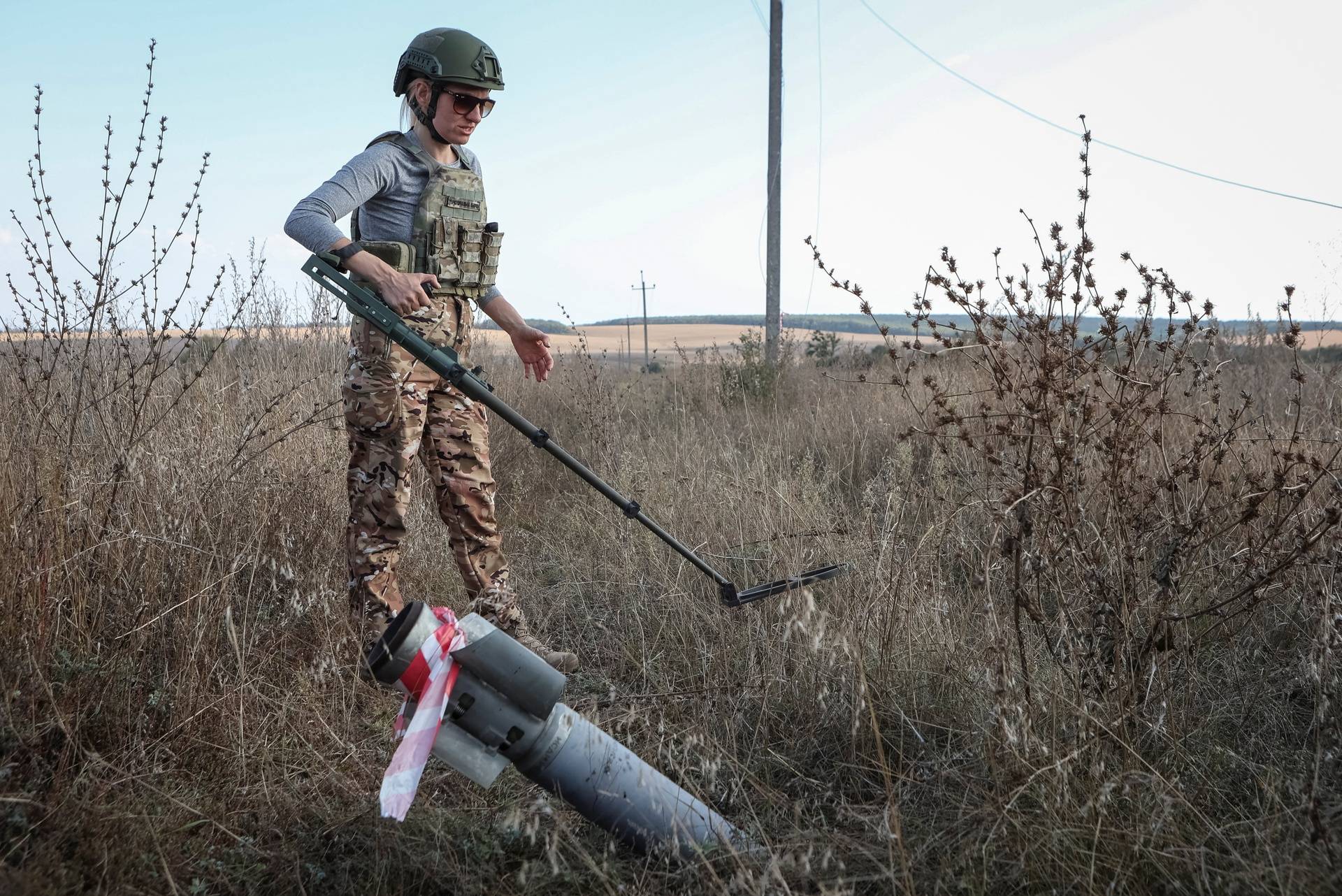 A member of the demining charitable fund 'Demining of Ukraine' works at a field near the town of Derhachi