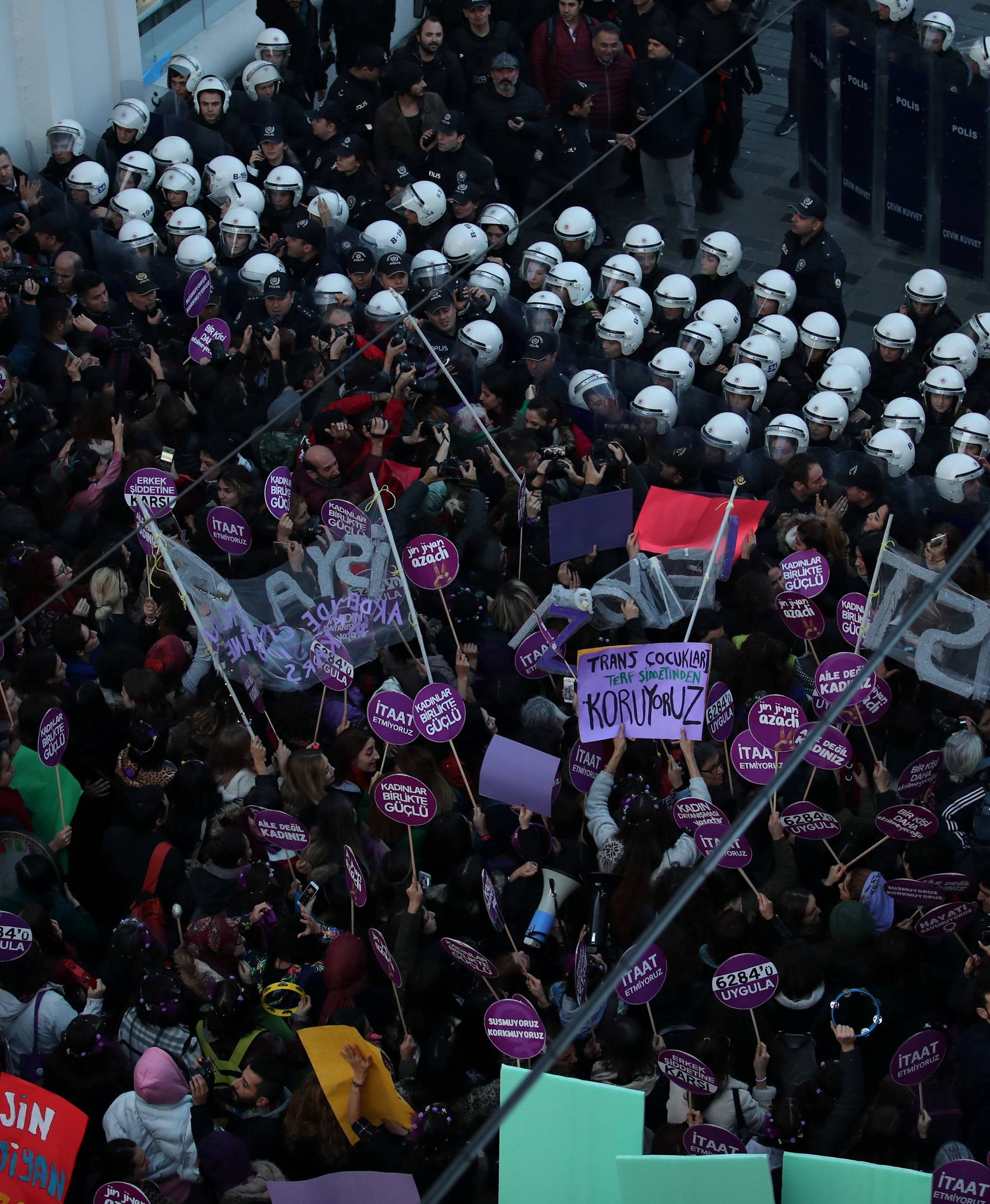 Riot police prevent women's rights activists march through Taksim Square to protest against gender violence in Istanbul