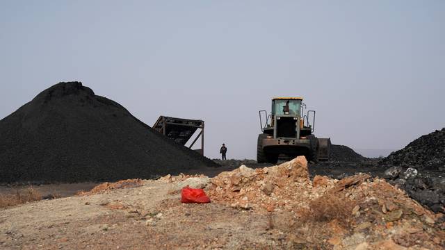 A man sifts through dunes of low-grade coal near a coal mine in Ruzhou