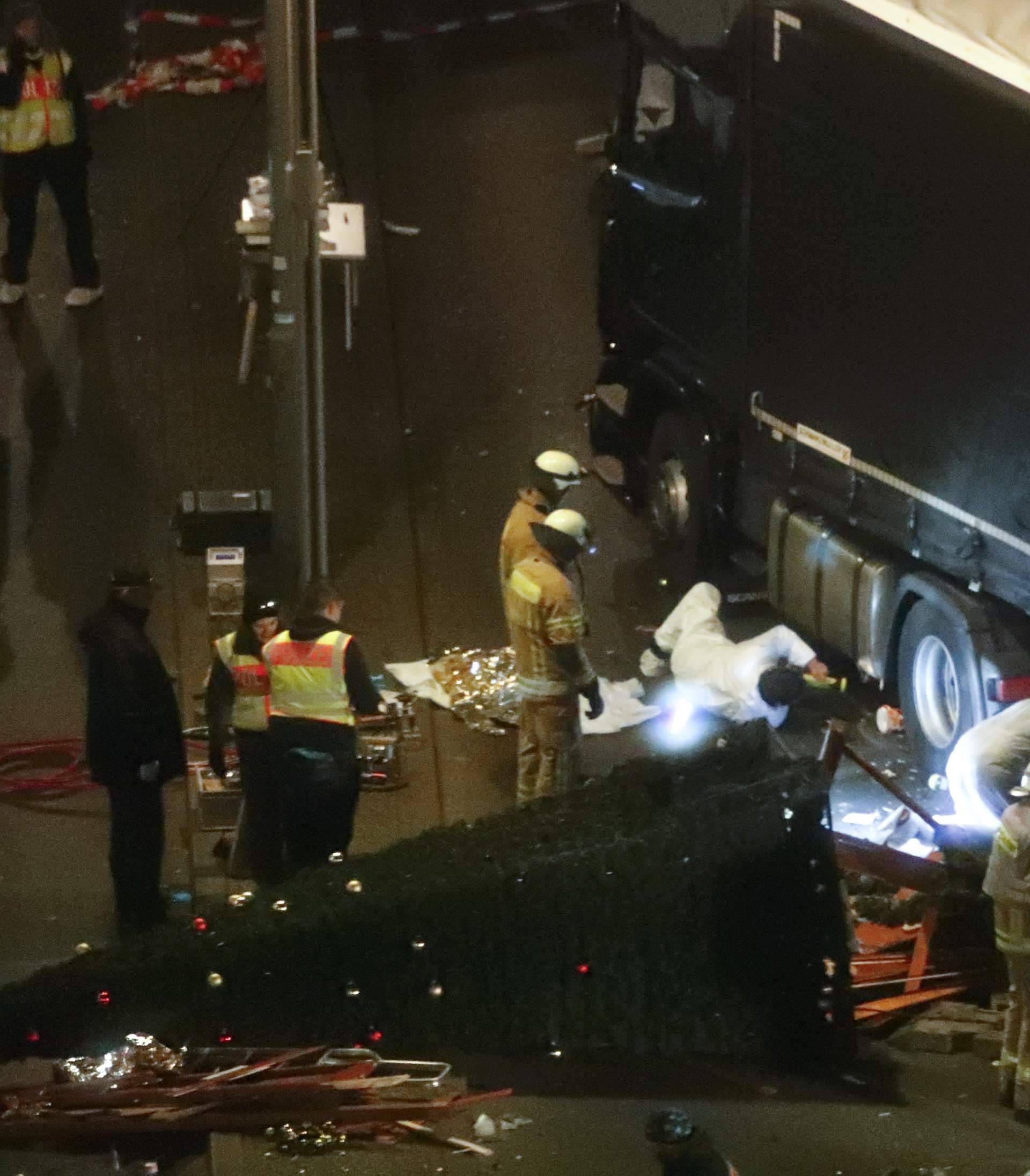 Rescuers and police investigators inspect a truck that ploughed through crowd of a Berlin Christmas market