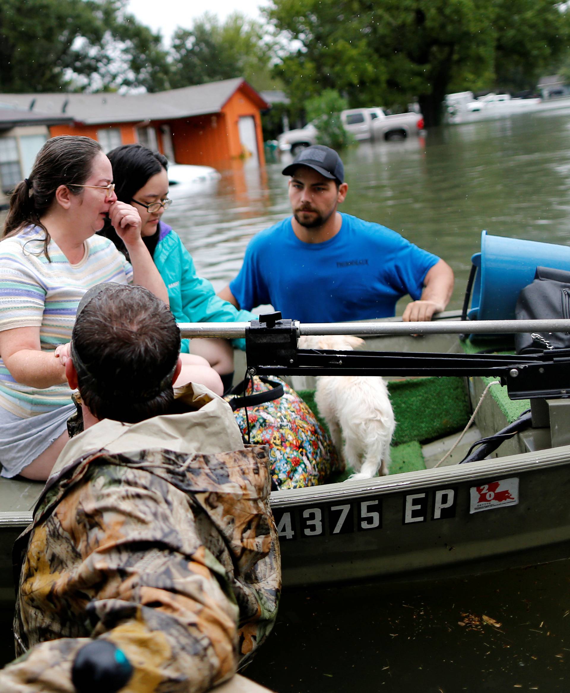 A woman is comforted after being rescued from her home flooded by Tropical Storm Harvey in Orange