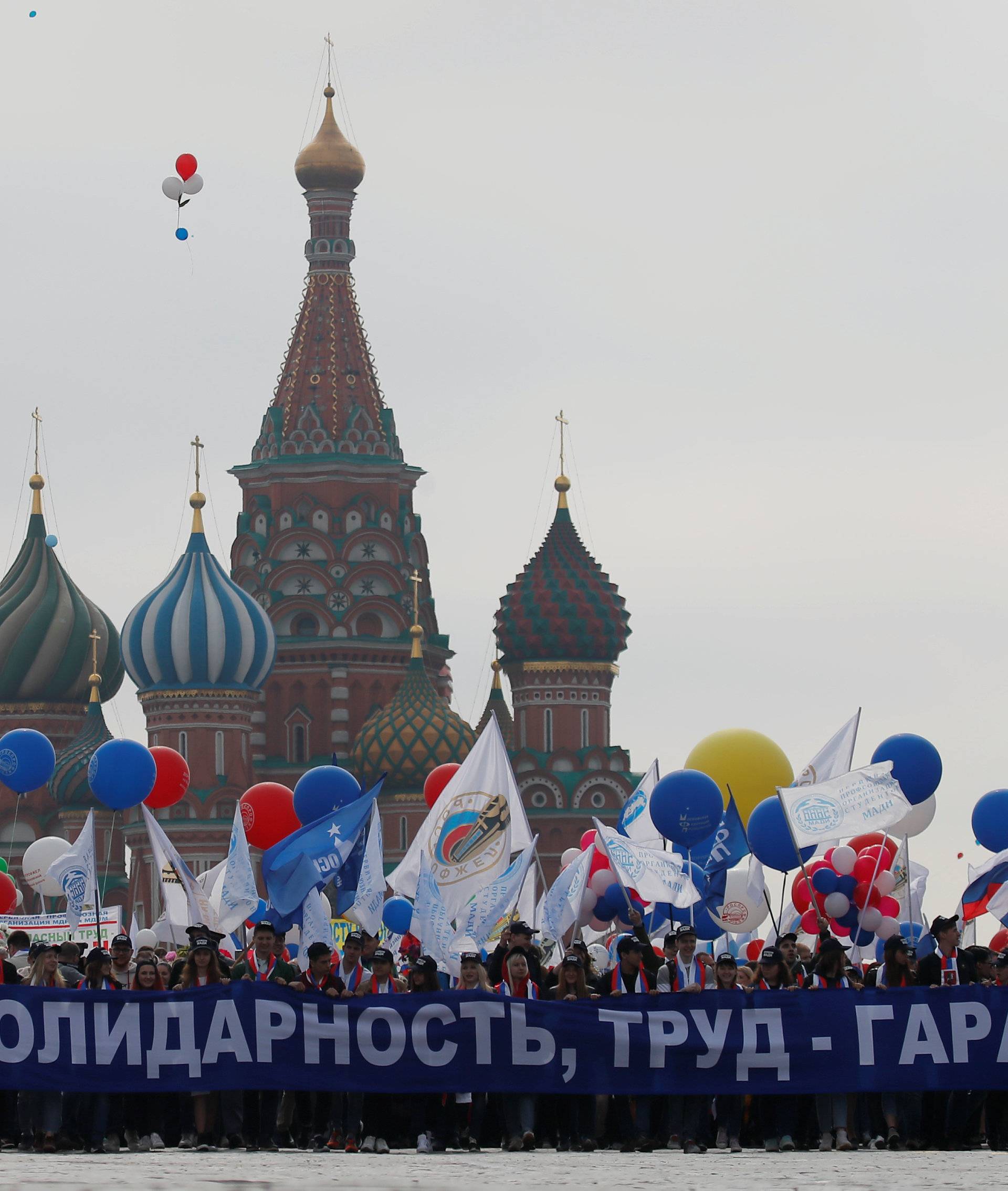 People carry a banner in front of St. Basil's Cathedral during a May Day rally at Red Square in Moscow