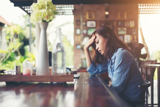 Young Woman Sitting in a Cafe with Her Laptop, Stressful for Wor