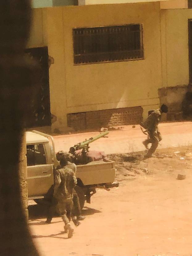 A military vehicle and soldiers said to be from the Sudanese armed forces are seen on a street in Khartoum