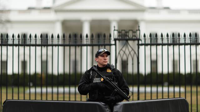 A uniformed Secret Service officer is pictured on scene after a passenger vehicle struck a security barrier near the White House in Washington