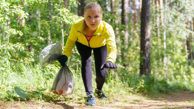 Woman,Jogger,Leans,Over,Trash,During,Plogging