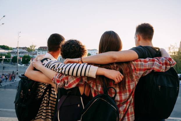 Happy young people hugging looking at city view
