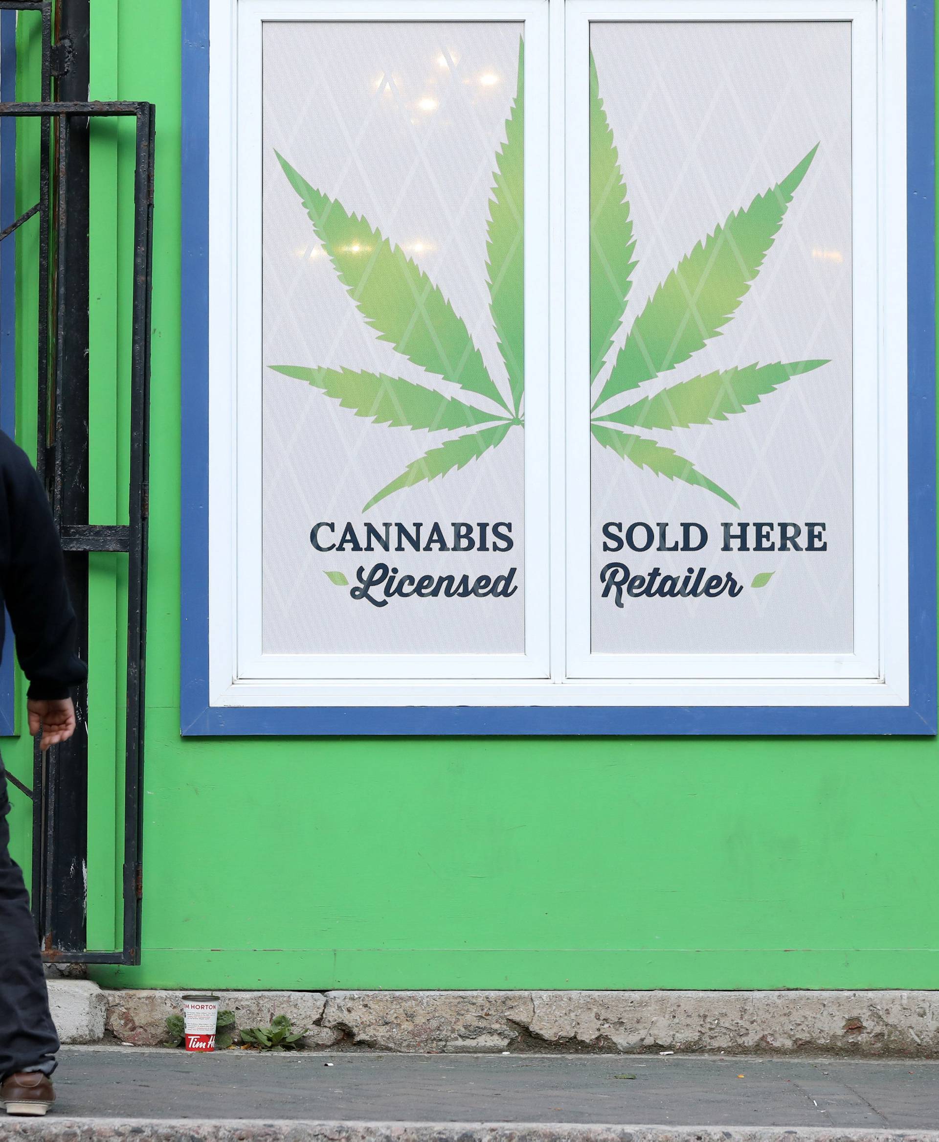 A man looks at a sign outside the Natural Vibe store after legal recreational marijuana went on sale in St John's