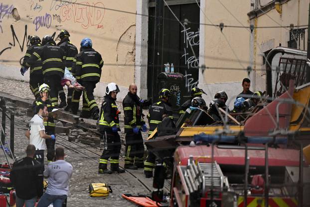 First responders work at the site of a funicular accident in Lisbon