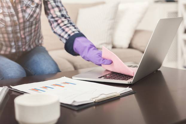 Unrecognizable woman cleaning laptop keyboard copy space